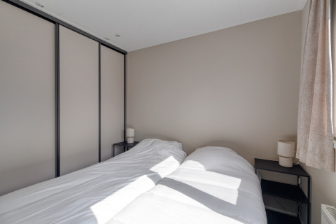 Modernes Schlafzimmer in der Natuurhoeve im Park Westerkogge, Niederlande, mit Doppelbett und Garderobeschrank.