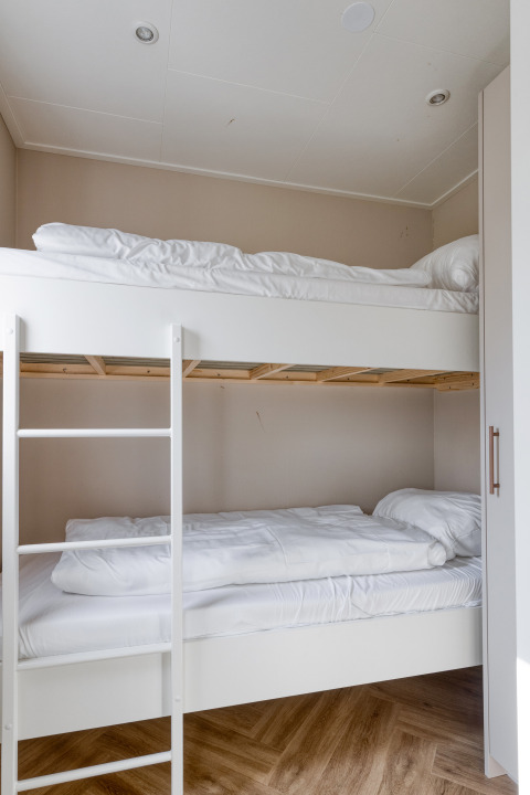 Lit superposé avec draps blancs dans une chambre du lodge Natuurhoeve à Park Westerkogge, Pays-Bas.