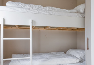 Lit superposé avec draps blancs dans une chambre du lodge Natuurhoeve à Park Westerkogge, Pays-Bas.