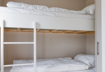 Lit superposé avec draps blancs dans une chambre du lodge Natuurhoeve à Park Westerkogge, Pays-Bas.