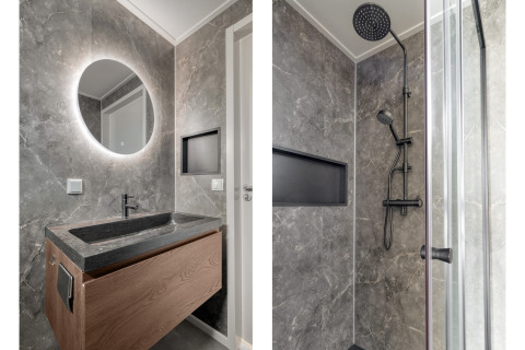 Salle de bain moderne à Natuurhoeve au Park Westerkogge, Pays-Bas, avec lavabo noir et douche pluie.
