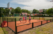 Bambini giocano su un campo polisportivo con canestri da basket a Camping Goorzicht, Olanda Settentrionale, Paesi Bassi.