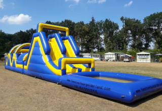 Grande scivolo d'acqua gonfiabile al Camping Goorzicht nel Noord-Holland, Paesi Bassi, su campo erboso.