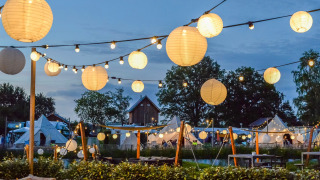Noche en Holiday Park Mölke en Overijssel, Países Bajos, con luces colgantes y tiendas de fondo.