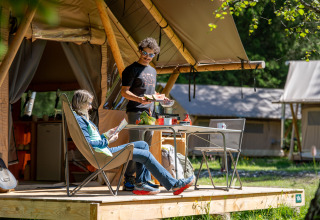 Deux personnes profitent du glamping à Huttopia Vanoise – Champagny en Auvergne-Rhône-Alpes, France.