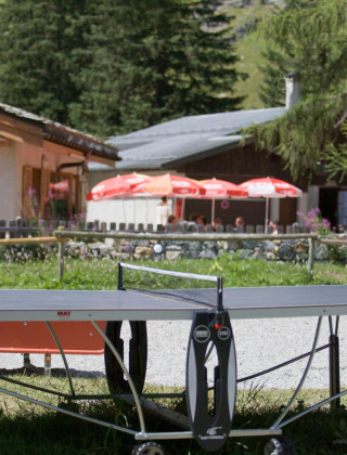 Two boys play table tennis outdoors at Huttopia Vanoise – Champagny glamping in Auvergne-Rhône-Alpes, France.