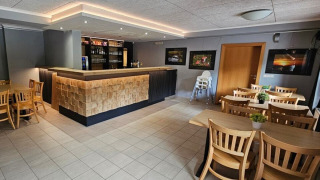 Bar moderne et espace repas en bois au Camping Reiler, situé à Clervaux, Luxembourg.