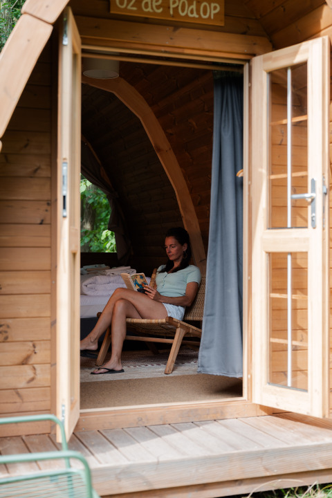 Frau liest entspannt ein Buch im Duo Panorama pød bei RØSTIG Dorst in den Niederlanden.