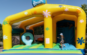 Child playing on a colorful bouncy castle at Flower Camping Le Kerarno, a holiday park in Brittany, France.