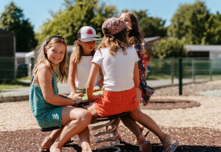 Kinder spielen gemeinsam auf einem Spielplatz im Flower Camping Le Kerarno Ferienpark in der Bretagne, Frankreich.