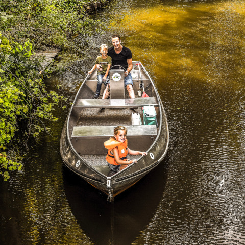 Familie sejler i båd på en flod ved Holiday Park Mölke, en populær feriepark i Overijssel, Holland.