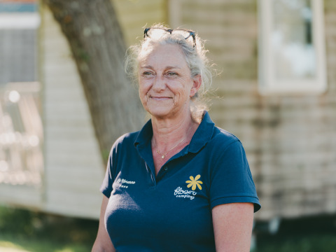 Female staff member in navy Flower Campings polo shirt at Flower Camping Le Kerarno holiday park, Brittany, France.