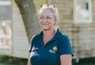 Female staff member in navy Flower Campings polo shirt at Flower Camping Le Kerarno holiday park, Brittany, France.