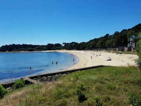 Peaceful sandy beach view at Flower Camping Le Kerarno holiday park in Brittany, France, on a sunny day.