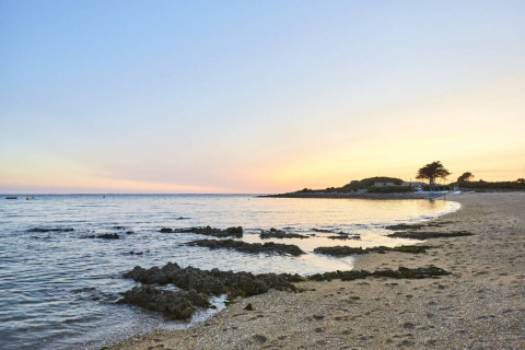 Coucher de soleil sur la plage paisible de Flower Camping Le Kerarno en Bretagne, France.