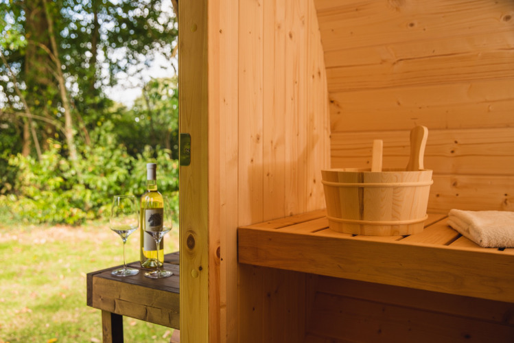 Innenaufnahme einer Holzsauna im Holiday Park Mölke, Overijssel, mit Wein und Gläsern draußen.