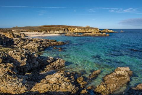 Rocky shoreline and clear blue sea at Flower Camping Le Kerarno, a holiday park in Brittany, France.