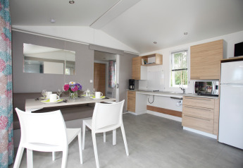 Bright mobile home Comfort Stacaravan PMR 29m2 with dining area and modern kitchen at Flower Camping Le Kerarno.