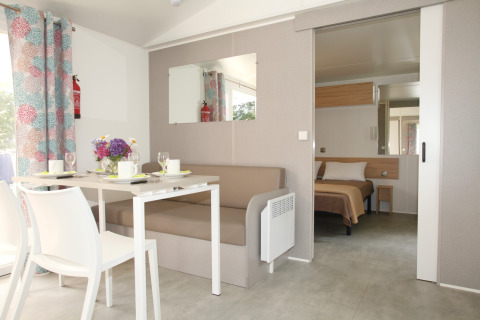Intérieur du Comfort Stacaravan PMR 29m2 avec salle à manger et chambre au Flower Camping Le Kerarno en France.