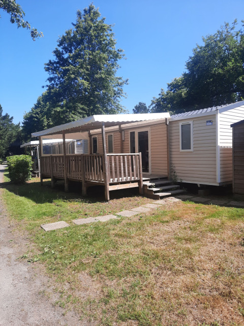 Comfort stacaravan 32m2 mobile home with porch at Flower Camping Le Kerarno in France on a sunny day.