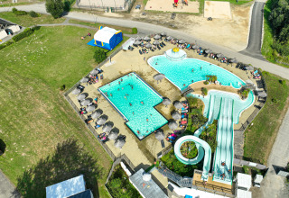 Luchtfoto van het zwembadcomplex, waterglijbanen en zonnebedden bij Flower Camping Le Vorlen in Bretagne.