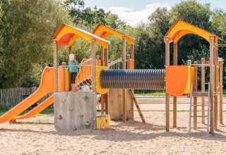 Spielplatz mit Rutsche, Kletterwand und Sand bei Flower Camping Le Vorlen in der Bretagne, Frankreich.