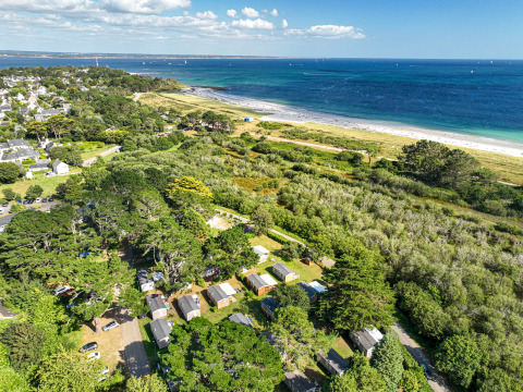 Luchtbeeld van Flower Camping Le Vorlen, vakantiepark aan een kust in Bretagne, Frankrijk, met veel groen.