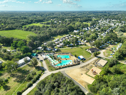 Luftaufnahme vom Flower Camping Le Vorlen in der Bretagne, Frankreich, mit Pools, Hütten und Natur.