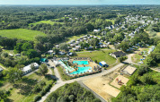 Luchtfoto van Flower Camping Le Vorlen in Bretagne, Frankrijk, met zwembaden, chalets en groene omgeving.