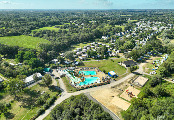 Luftaufnahme vom Flower Camping Le Vorlen in der Bretagne, Frankreich, mit Pools, Hütten und Natur.