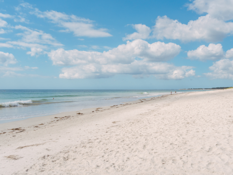 Ruhiger Sandstrand mit blauem Meer und Himmel im Flower Camping Le Vorlen in der Bretagne, Frankreich.