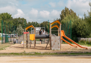 Parco giochi con scivolo e parete da arrampicata al Flower Camping Le Vorlen, villaggio vacanze in Bretagna, Francia.
