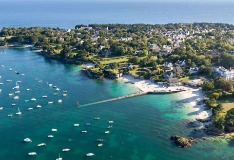 Veduta aerea di Flower Camping Le Vorlen, parco vacanze in Bretagna, Francia, con barche e costa verde.