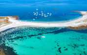 Aerial view of boats and sandy beach at Flower Camping Le Vorlen holiday park in Brittany, France.