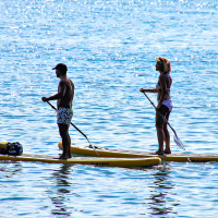 Due persone fanno paddleboard su tavole gialle vicino a Manerba del Garda, in Lombardia, Italia.
