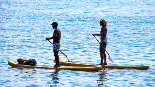 Due persone fanno paddleboard su tavole gialle vicino a Manerba del Garda, in Lombardia, Italia.