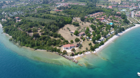 Luchtfoto van Sivinos Camping Boutique in Lombardije, Italië, met strand, groen en vakantiehuisjes.