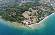 Vista aerea di Sivinos Camping Boutique in Lombardia, Italia, con spiaggia, aree verdi e case vacanza.
