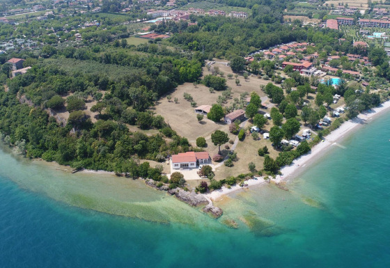Luftfoto af Sivinos Camping Boutique i Lombardiet, Italien, med strand, grønt område og feriehuse.