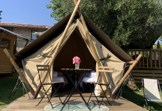 Tente safari junior au Sivinos Camping Boutique en Italie, avec terrasse en bois, table et chaises dehors.