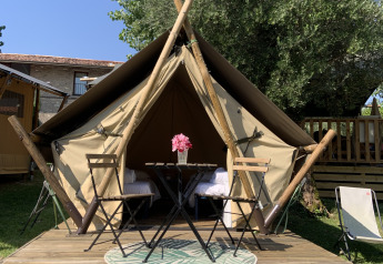 Tienda safari junior en Sivinos Camping Boutique en Italia, con plataforma de madera, mesa y sillas.