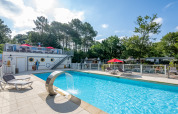 Udendørs swimmingpool med solstole og springvand ved Flower Camping La Canadienne i Nouvelle-Aquitaine, Frankrig.