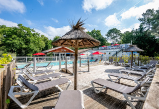 Espace piscine extérieur avec transats et parasols au Flower Camping La Canadienne en Nouvelle-Aquitaine, France.