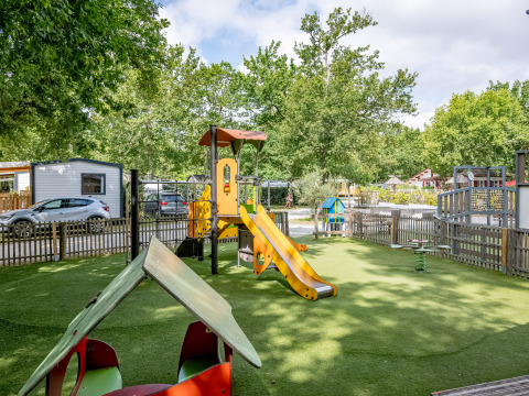 Aire de jeux avec toboggan et structures chez Flower Camping La Canadienne en Nouvelle-Aquitaine, France.