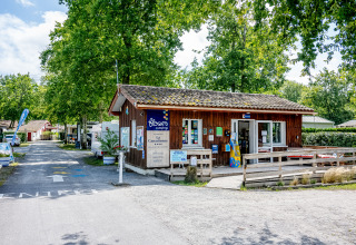 Entrada y recepción de Flower Camping La Canadienne, ubicada entre árboles en Nouvelle-Aquitaine, Francia.