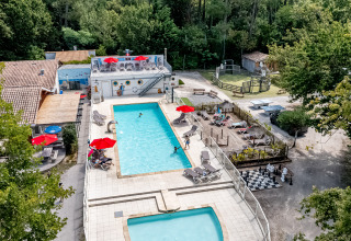 Luftaufnahme vom Pool, Liegestühlen und Spielplatz im Flower Camping La Canadienne, Nouvelle-Aquitaine.