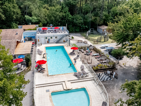 Vista aérea de la piscina, tumbonas y zona de juegos en Flower Camping La Canadienne, Nouvelle-Aquitaine, Francia.