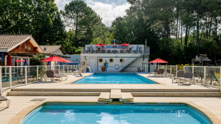 Zwembad en ligstoelen bij Flower Camping La Canadienne, een vakantiepark in Nouvelle-Aquitaine, Frankrijk.