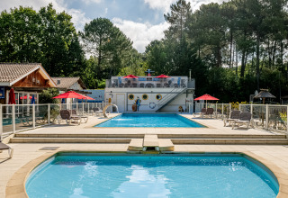 Poolbereich mit Sonnenliegen im Flower Camping La Canadienne, Ferienpark in Nouvelle-Aquitaine, Frankreich.