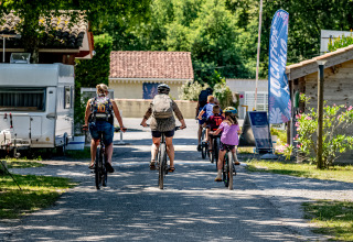 Familien fahren Fahrrad im Flower Camping La Canadienne, einem Ferienpark in Nouvelle-Aquitaine, Frankreich.